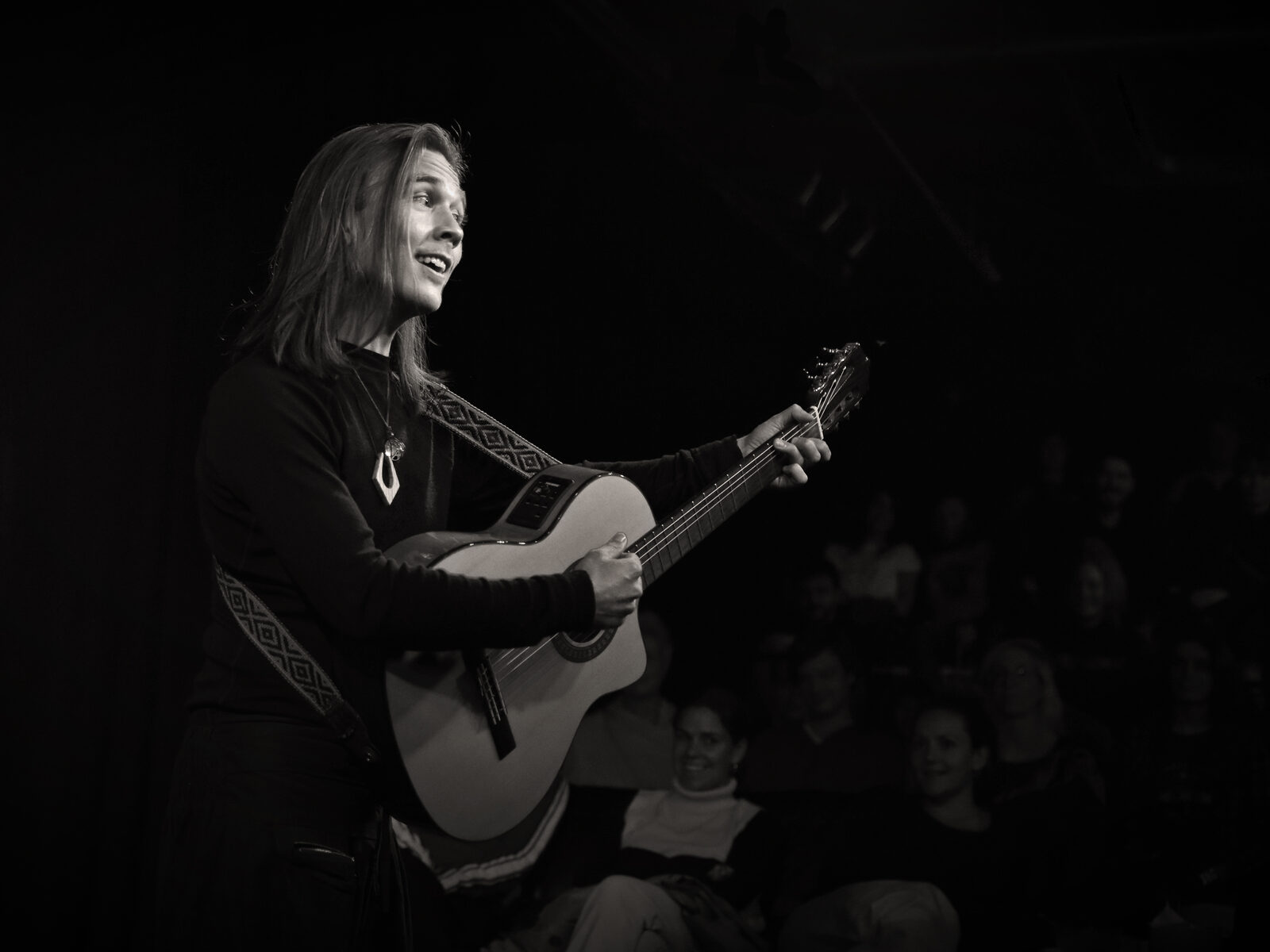 Performing with guitar to a seated audience at Mezrab, Amsterdam